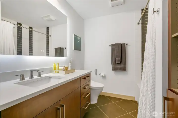 Quartz countertop, sink & faucet fixture and backlit bathroom mirror.