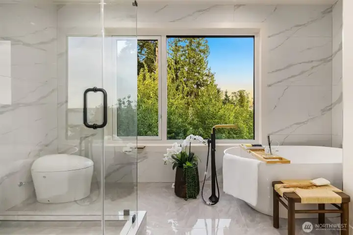 Serene spa retreat with a freestanding soaking tub, glass-enclosed shower, and lush treetop views