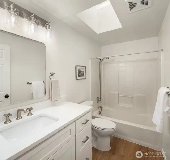 Full bathroom features a new vanity, flooring and finishes.
