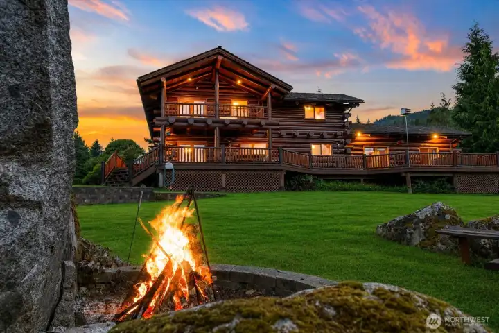 Roast marshmallows under the stars beside the massive natural boulder fire pit, creating the ultimate gathering space for unforgettable evenings.