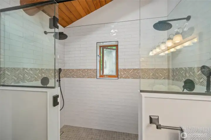 Huge shower: Enjoy dual shower heads, a full tile surround, and a window that invites in fresh air and natural light for a spa-like experience.