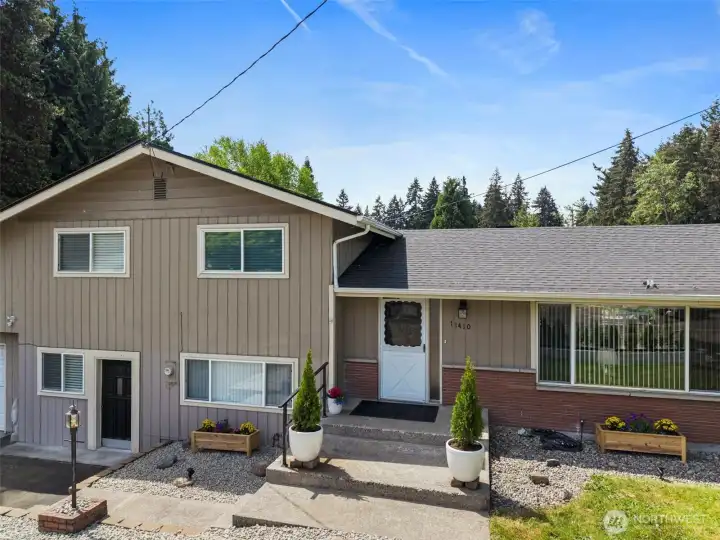 Nice curb appeal & low maintenance landscape highlight the front of the home. New gutters were installed in 2023 plus new attic insulation & solar roof fans. The black door on the left is the exterior access to the possible ADU/multi-generational living or business space