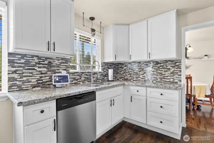 Slab granite countertops & glass tile backsplash offer beauty & functionality