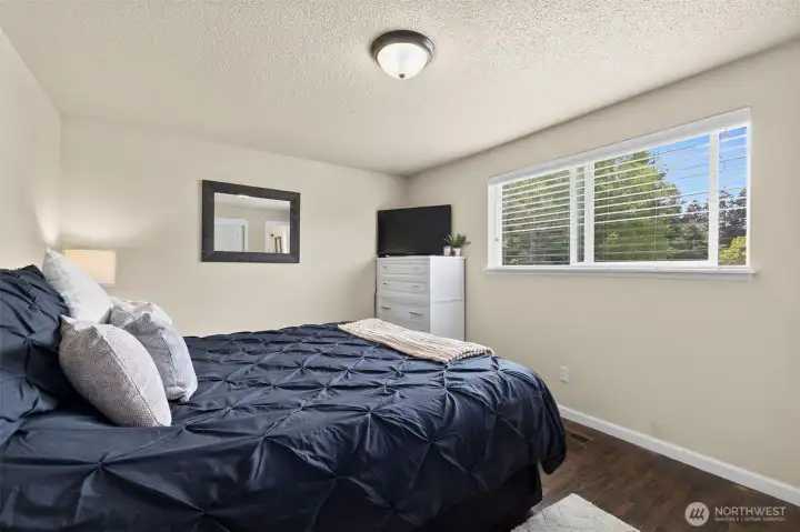 The roomy primary bedroom is tucked at the back of the home & provides a pretty back yard view