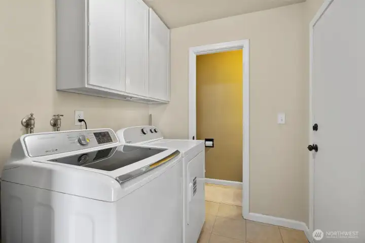The laundry room with tile flooring and added storage and the 1/2 bath are adjacent to the bonus space. The washer & dryer are also included