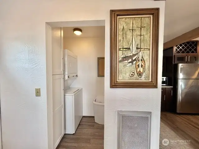 Laundry area with storage next to front door.