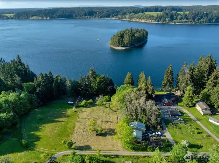 The mowed area is part of your property and sits above the sound frontage.  It's flat and has room for at least one house.  Right now the structure you see on it is the well house.  Your driveway is to the right of your lot.  Imagine the possibilities of an ADU & your on the water view home.
