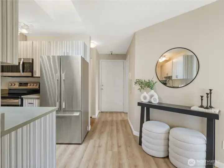 Step inside to a welcoming entryway that flows seamlessly into the kitchen, showcasing updated flooring, contemporary finishes, and plentiful storage. Step inside to a welcoming entryway that flows seamlessly into the kitchen, showcasing updated flooring, contemporary finishes, and plentiful storage.