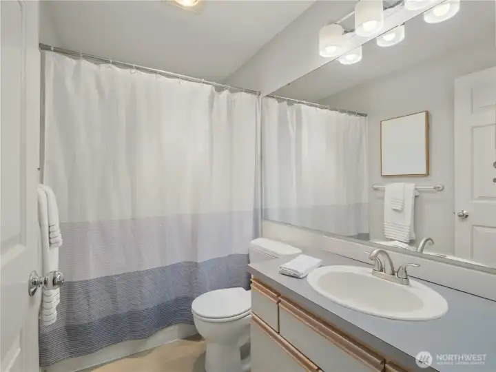Clean lines and a practical layout define this full bathroom, complete with a large mirror and convenient storage space. Clean lines and a practical layout define this full bathroom, complete with a large mirror and convenient storage space.