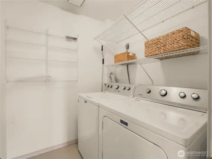 Functional laundry room offering full-size washer and dryer, built-in shelving, storage space, and room for everyday organization. Functional laundry room offering full-size washer and dryer, built-in shelving, storage space, and room for everyday organization.