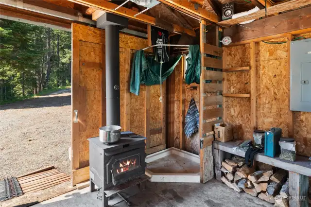 This is your shower! Smart setup with wood burning stove to heat water, & a pulley system to fill your sunshower & hoist up. Very efficient!