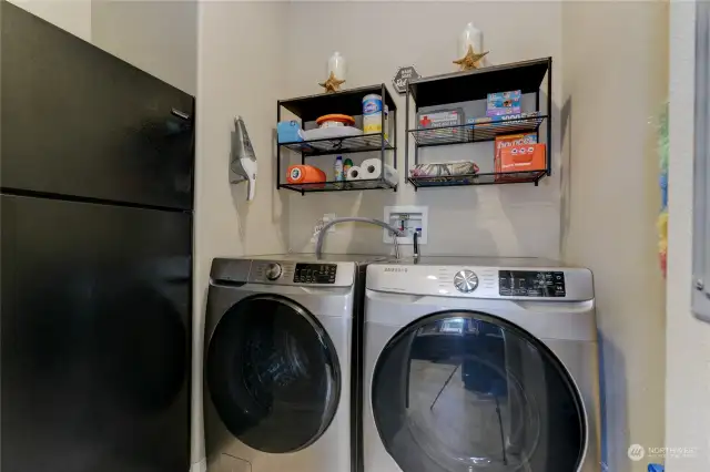 Behind the barn door in the kitchen is this lovely laundry room with additional storage space!