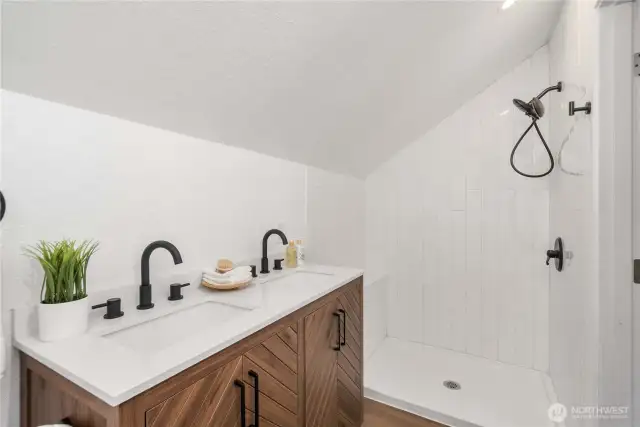 Primary bath has a double sink vanity and tiled shower. Custom mirror is on the way!