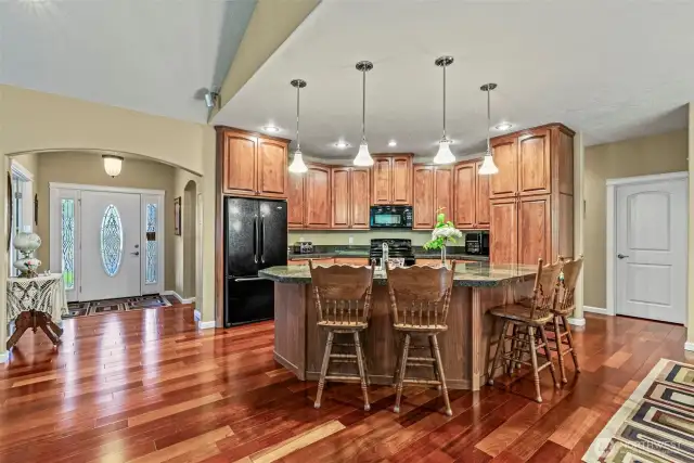 Brazilian cherry floors at entry, kitchen, dining and hallways. Custom Beech cabinetry w/pull-out features, full height uppers.  Large island with seating for 6 has 9' ceilings, can lighting and pendants. Black appliance package with ceramic-top range & convection oven.