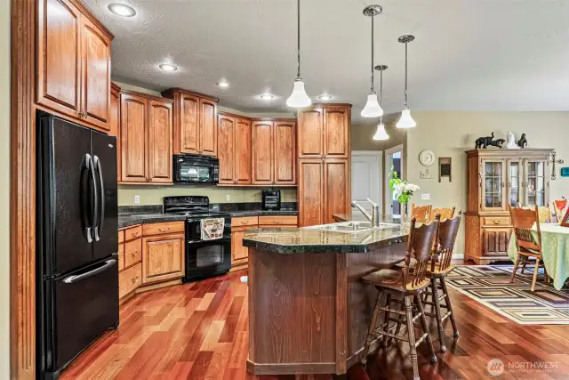 Granite tile countertops and conveniently laid-out placement of appliances, sink and pantry cabinets for great flow and open concept to great room and dining room.