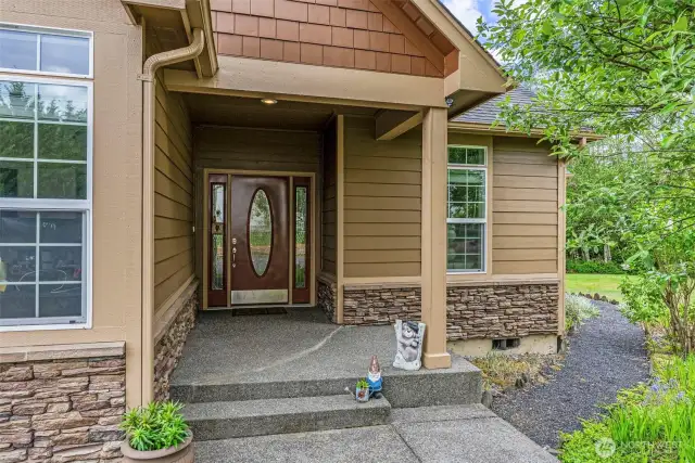 Aggregate walkway, steps and porch and gorgeous covered entry greet your guests.