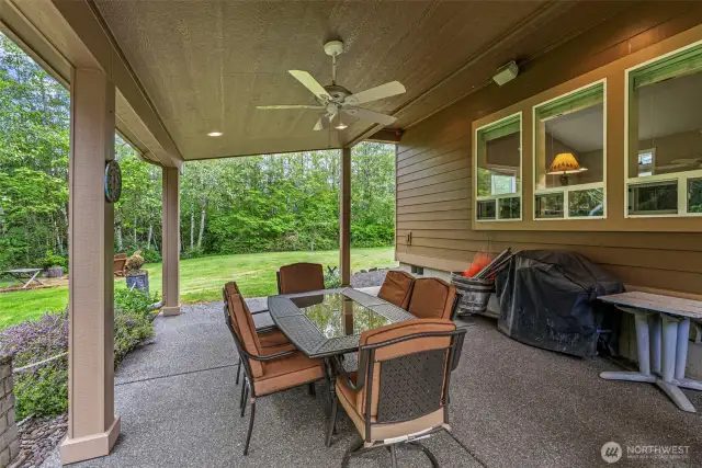 Covered aggregate concrete patio with surround sound & ceiling fan is the perfect place for dining al fresco!