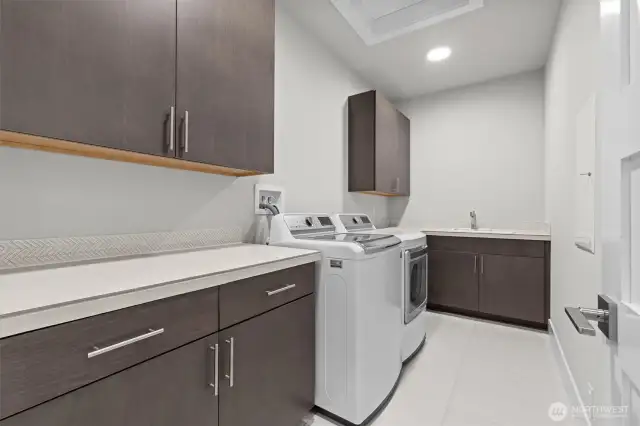 Spacious utility room with plenty of cabinet space, countertop space and sink