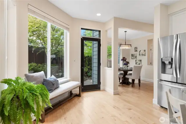 View from the kitchen looking toward the back door and private patio, with the dining area elegantly framed in the background.