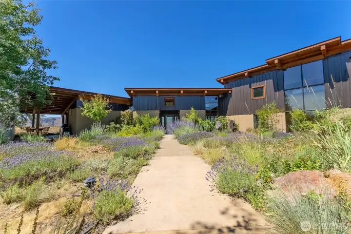 The entry courtyard is flanked by the four distinct sections of the home, and is landscaped with drought-resistant plantings, including many natives.
