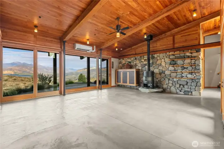 Back into the great room with views that don't stop, built in shelves and cupboards, a large river-rock wall and a beautiful granite footing for the Rais wood stove.
