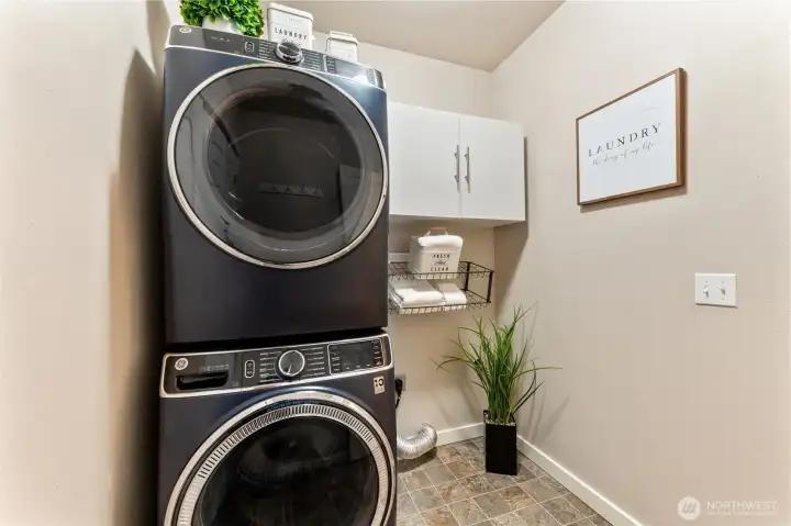 Laundry room off of kitchen with storage space and full size laundry center that stays.