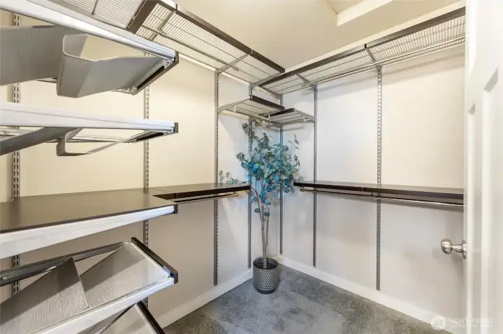 Roomy walk in closet with organizers.