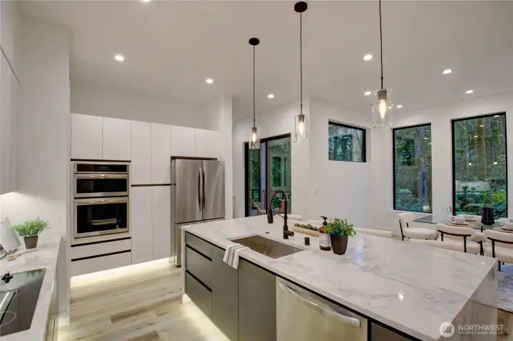 Open kitchen with massive slab Quartz island as the centerpiece.