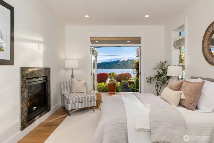 The primary bedroom ensuite features another set of French doors that lead to the gorgeous gardens and waterfront beyond.