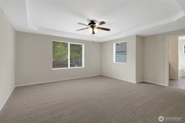 Upstairs primary bedroom with ceiling fan and great natural light.