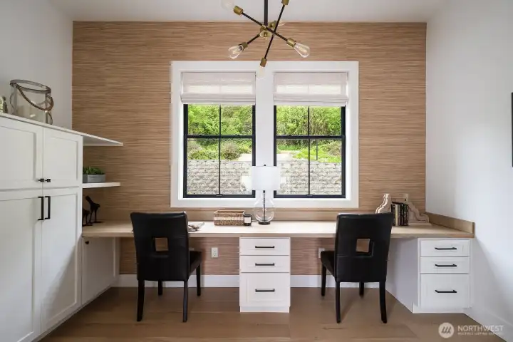 In home office with a plethora of built in cabinets.