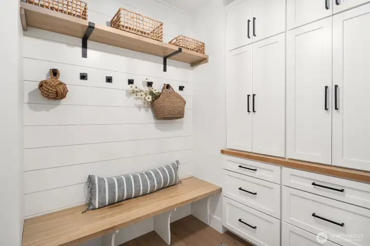 A mudroom off of the garage with tons of built in cabinets and storage space.
