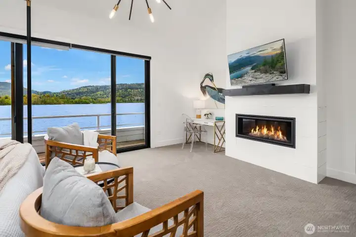 A romantic fireplace in the primary suite with dreamy lake and mountain views.