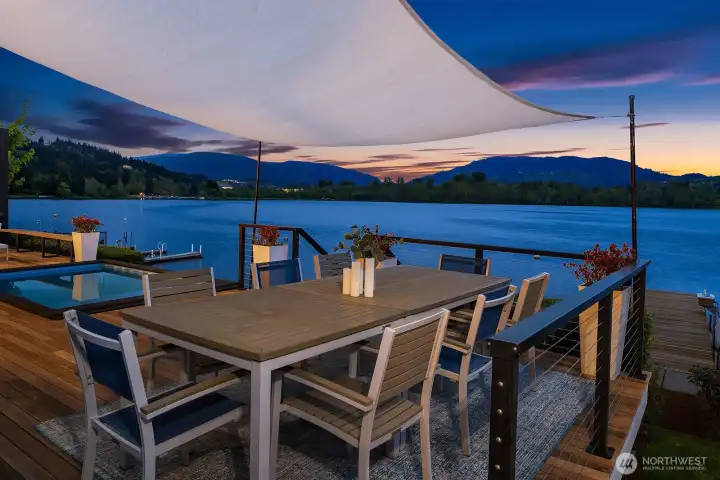 The outdoor dining area connects with the private dock at the shore's edge.