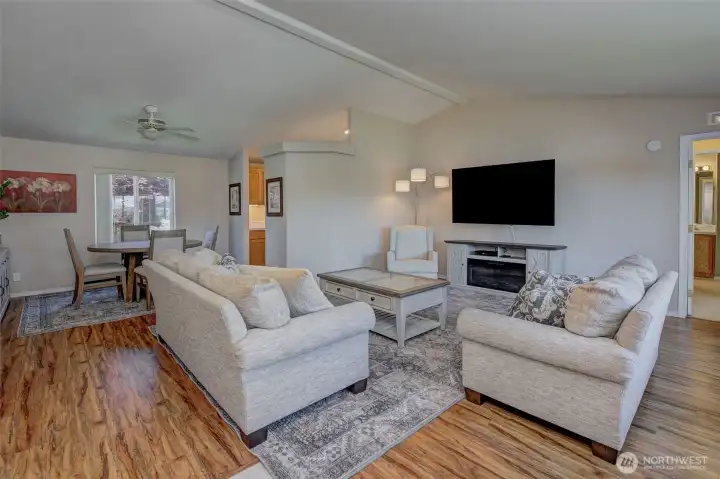 Living room feels warm and welcoming with hickory LVP floors, new paint and classy furnishings