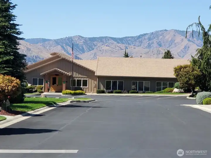 Looking at the very large community clubhouse from the east... clubhouse contains indoor pool, spa, fitness facility, meeting hall, kitchen, book nook and more!