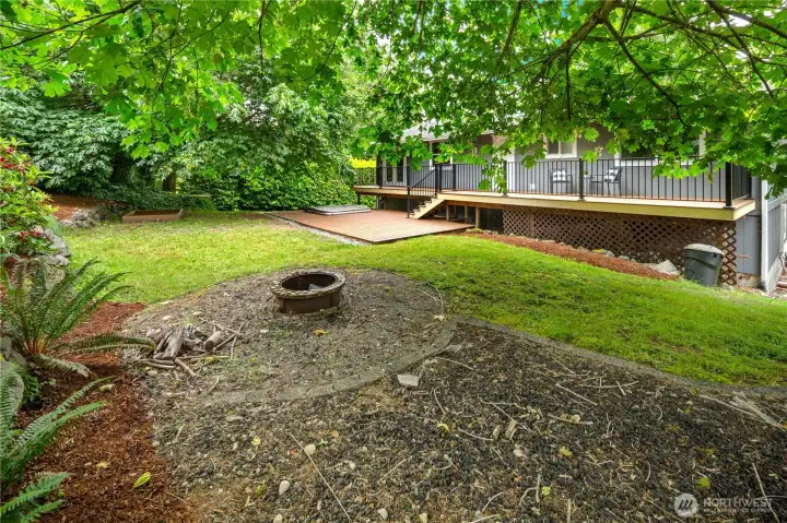 Lush, beautiful backyard with firepit, custom sandbox, tree swing & hot tub.