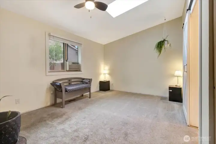 Primary bedroom with vaulted ceilings and skylight. Primary bedroom with vaulted ceilings and skylight.
