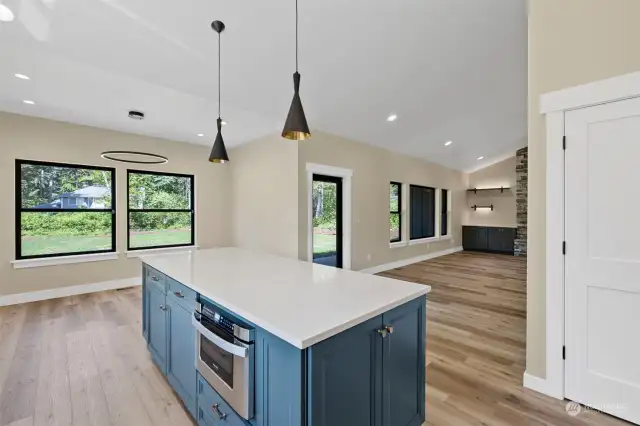This angle shows looking from the kitchen to the dining area beautiful lighting fixtures throughout this high end home. Note the door that leads to the covered patio where you can enjoy the beauty of nature from your own back yard