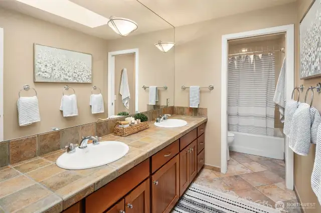 Full hallway bath with dual sinks + separate commode/shower room.