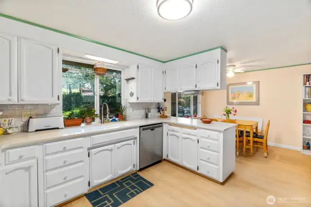 Back yard is visible through the window, with eat-in nook in the background.