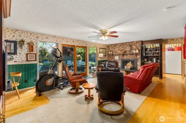 Large family room faces the back yard and features a gas fireplace. Laundry room visible in the background.