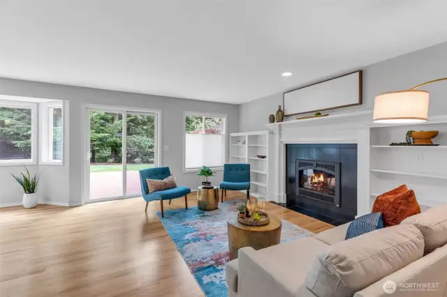 The family room features hardwood floors, custom bookshelves, a gas fireplace, and beautiful lighting, creating a ward and inviting space.