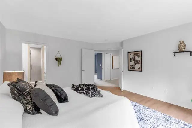 The primary bedroom features elegant double doors that open to a spacious reteat, showcasing stunning laminate flooring.