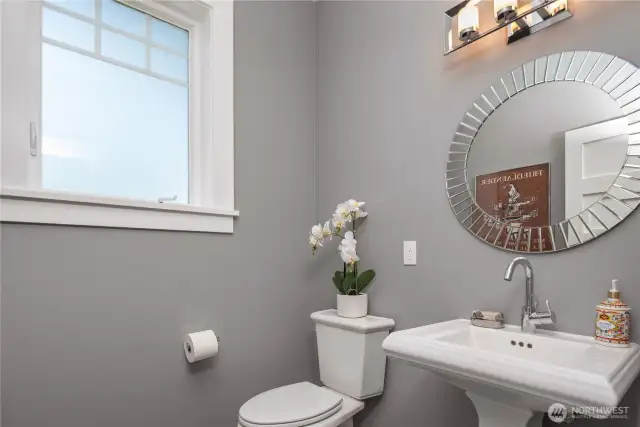 A discreet powder room is located on the main floor with a pedestal sink.