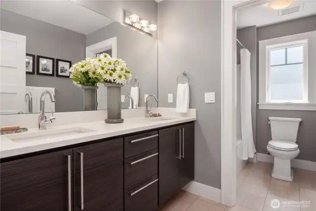 The main bath also has two undermount sinks and lots of storage. The full bath is just beyond with a second door separating the rooms.