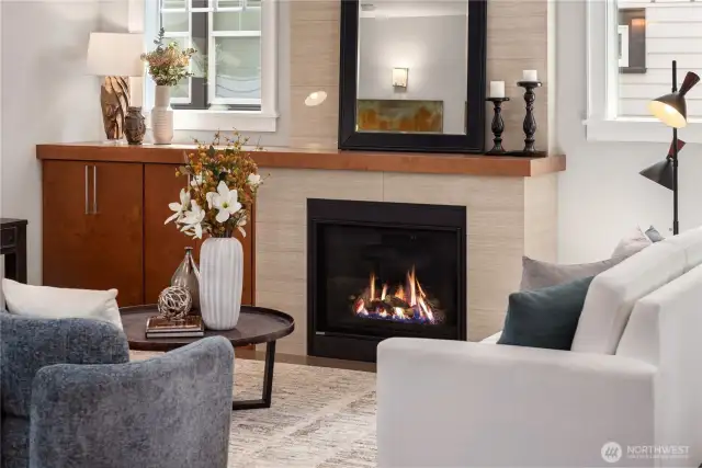 The gas fireplace features a tiled floor-to-ceiling face which plays beautifully off the natural wood mantle and cabinetry.