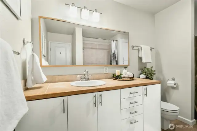 Spacious bathroom with storage cabinet that can be replaced with a stackable washer/dryer.
