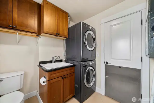 Convenient touches in  the laundry room include a utility sink and half bath,  and access to the outside.