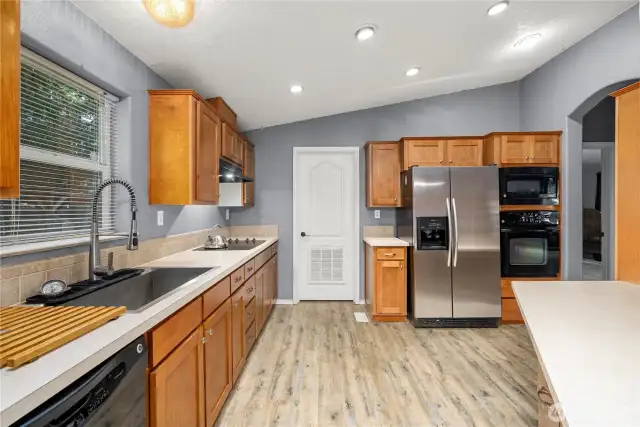 Kitchen with dishwasher, glass cooktop, stainless steel side-by-side refrigerator, built-in microwave and stove